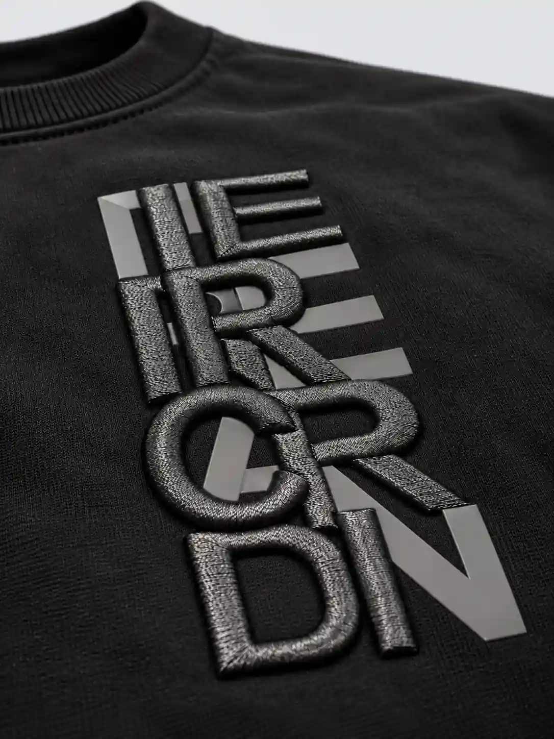 Close-up of raised foam-backed embroidery lettering combined with flat silicone chest print
