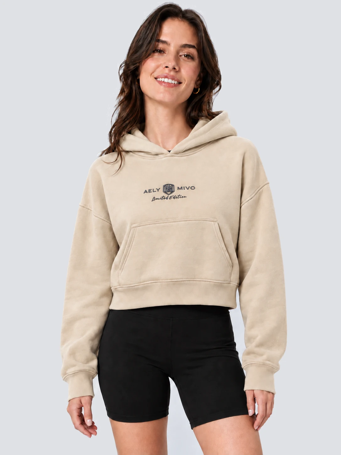 Women's cropped pullover hoodie front with embossed chest lettering and metal badge