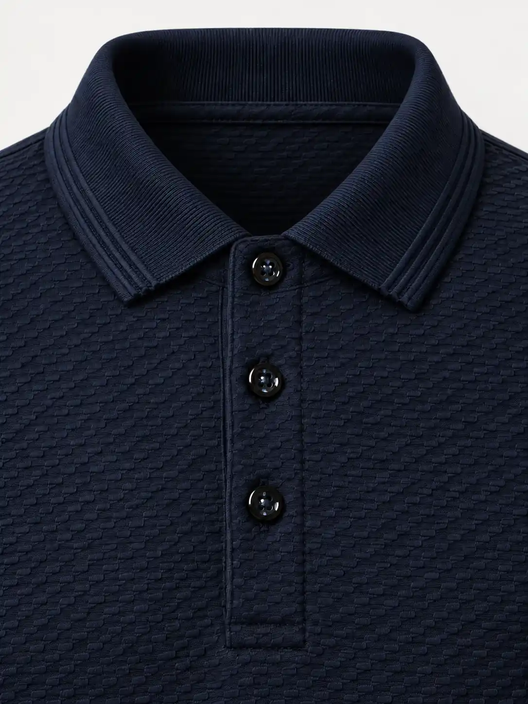 Close-up of the tonal navy flat-knit collar with integral knitted edge detailing and closed three-button placket on mini-brick jacquard